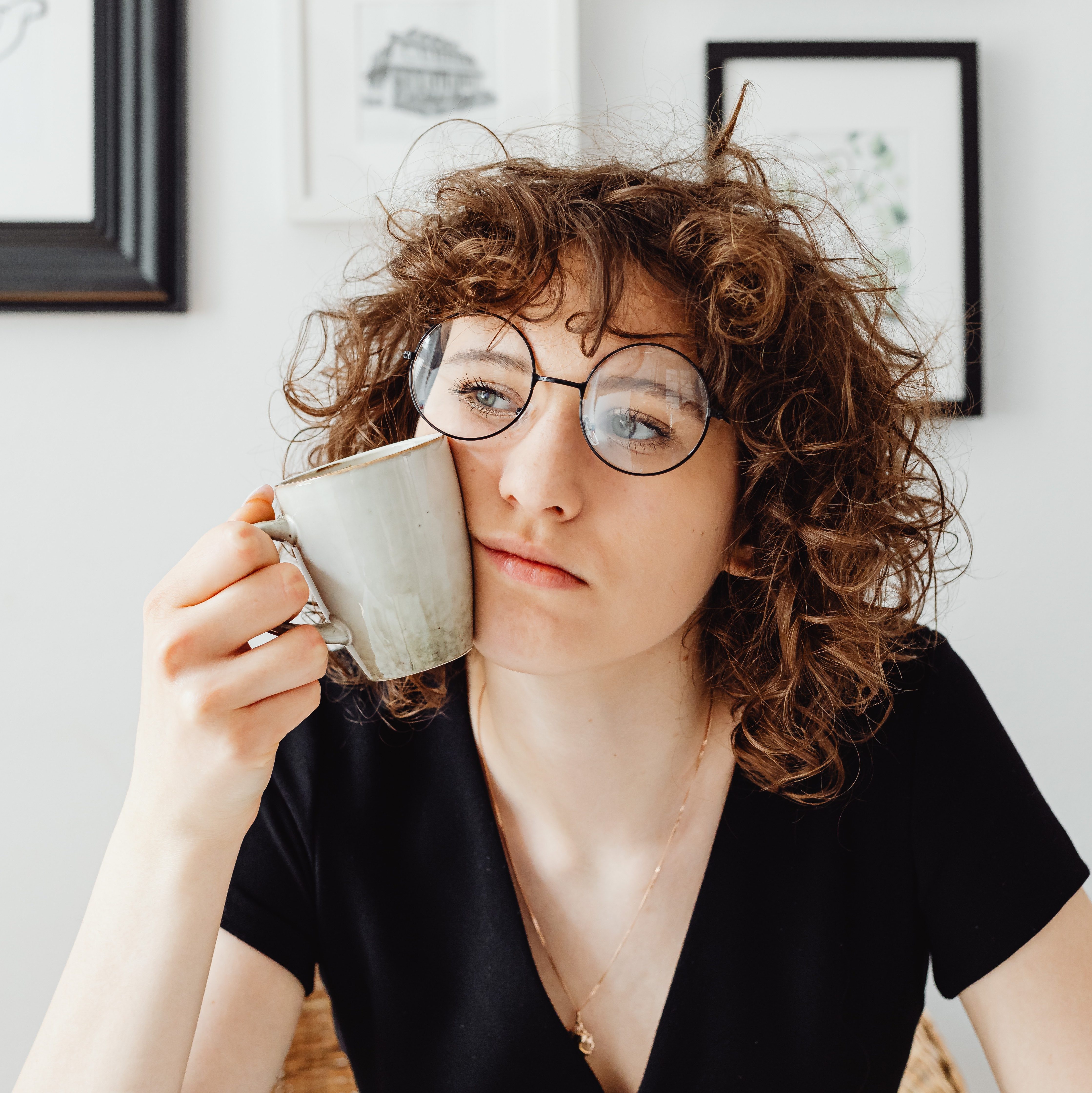 Woman thinking with coffee mug in hand