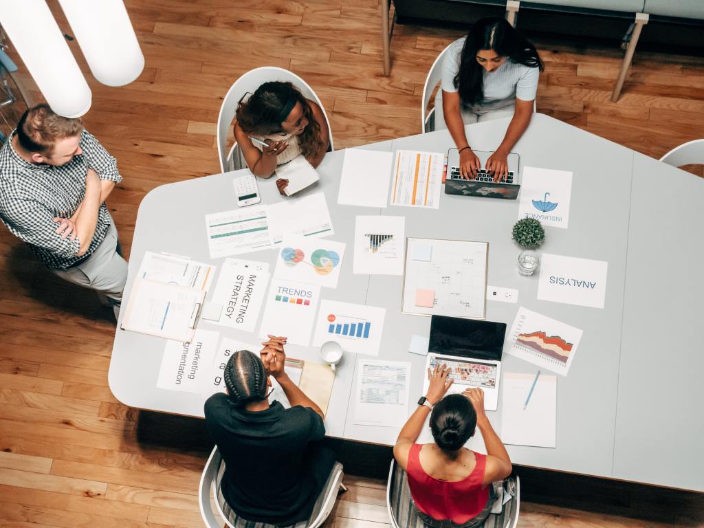 Group of colleagues looking at graphs around a table